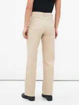 Jean de mujer color beige claro, de corte recto y tiro alto, con cinco bolsillos y cierre de botón y cremallera.