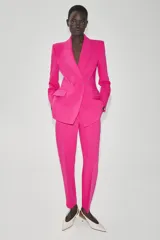 Blazer cruzado fucsia con cuello solapa, manga larga, bolsillos con solapa en el delantero y cierre frontal con botones forrados.
