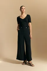 Top de manga corta confeccionado en tejido jacquard con textura en relieve. Presenta escote en V y un diseño frontal con líneas diagonales que crean un efecto cruzado.