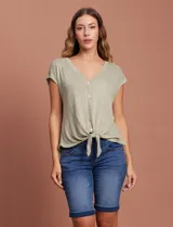 Blusa color beige de modal con escote en V, abertura central con botones y ruedo anudado. Marca French Laundry.