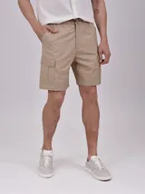 Bermuda de gabardina color verde militar, con cintura elástica ajustable con cordón, bolsillos laterales y bolsillo cargo con solapa en la pierna.