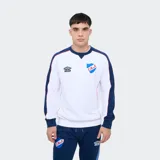 Buzo deportivo Umbro del Club Nacional de Football, color blanco con mangas y detalles en azul marino y rojo. Presenta cuello redondo, el logo de Umbro y el escudo del club bordados en el pecho.