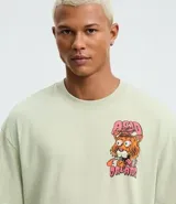 Remera de algodón color verde claro, de corte relajado, cuello redondo y manga corta. Presenta un estampado grande en la espalda de un tigre con ojos saltones y la frase "Acid Dreams" en tonos rosados y naranjas.