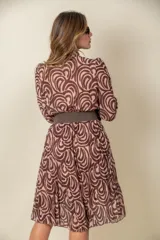 Vestido midi marrón con estampado abstracto en tonos beige, corte cruzado, cuello en V, mangas 3/4 y falda plisada. Incluye cinturón marrón con hebilla rectangular.