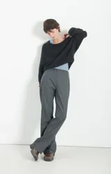 Polerón de punto negro con textura esponjosa, corte holgado y mangas largas. Presenta un diseño de cuello redondo y acabado suave al tacto.