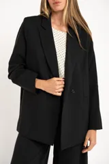 Blazer negro de corte oversize, con solapas de muesca, cierre frontal con un botón y bolsillos delanteros con solapa.