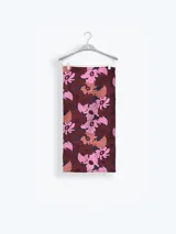 Pareo estampado de diseño floral con predominio de tonos bordó, rosado y marrón.