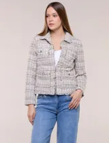 Chaqueta confeccionada en tejido de tweed beige con trama estructurada. Presenta cuello con solapa, frente abierto con botones metálicos y cuatro bolsillos funcionales. Las mangas largas de calce recto cuentan con bocamangas decoradas con botones y terminaciones deshilachadas al igual que los bordes.