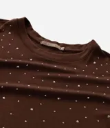 Remera de malla color tostado con cuello redondo, mangas cortas y aplicación de strass salpicado en toda la prenda.