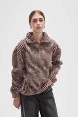 Buzo de textura afelpada con diseño de rayas horizontales finas en tonos marrones. Presenta cuello alto con cierre frontal parcial y mangas largas holgadas.