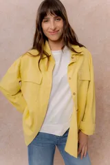 Camisa oversize de denim liviano color amarillo, con cuello camisero, mangas largas con puños, bolsillos delanteros con tapa y ruedo desflecado.