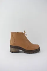 Borcego color suela de cuero con plataforma tractorada, cordones y cierre lateral.