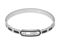 Pulsera esclava de acero con eslabones decorados con esmalte negro y un eslabón central alargado que contiene tres circonias móviles.