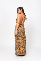Vestido largo color ocre con estampado floral, escote en V y espalda descubierta.