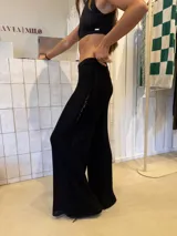Pantalón negro de tejido de punto con entrelazado en los laterales.