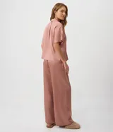 Pijama americano de satén color rosa viejo, compuesto por una camisa de manga corta con cuello solapa y botones frontales, y un pantalón largo de corte recto con cintura elastizada.