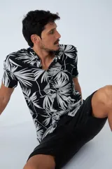 Camisa de manga corta con estampado botánico de hojas en tonos azul y blanco. Presenta cuello clásico, cierre frontal abotonado y corte slim.