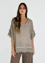 Blusa color beige de corte holgado, con escote en V y mangas cortas con detalle de flecos.