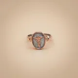 Anillo de diseño ovalado con el símbolo de la medicina (caduceo) en relieve, elaborado en combinación de plata 925 y oro 9k.