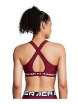 Top deportivo de soporte medio Under Armour, color bordó, con diseño de espalda cruzada y banda elástica inferior con logo de la marca. Confeccionado en tejido HeatGear de doble capa, con copas extraíbles y perforaciones para mayor transpirabilidad.