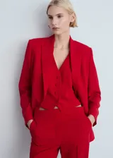 Chaleco de estilo sastre color rojo, con cuello en pico, cierre frontal de botones y bolsillos de ribete delanteros.
