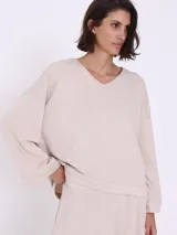 Sweater color visón con escote en V y corte asimétrico.