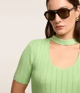 Blusa de tricot color verde claro, de manga corta y escote redondo con abertura frontal.