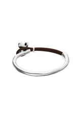 Pulsera semirígida compuesta por una estructura de plata de ley y una sección de cuero marrón, con un dije central en forma de mariposa de plata.