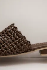 Zueco de cuero trenzado color tostado, con diseño destalonado, punta cuadrada y taco bajo estructurado.