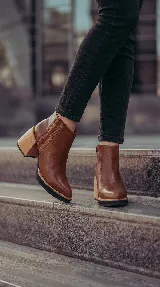 Botineta de cuero marrón con taco ancho efecto madera, plataforma sutil y detalles de elástico texturizado en los laterales.