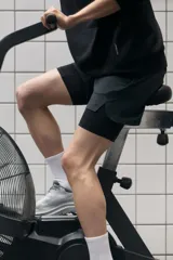 Short deportivo de doble capa con tecnología DryMove para absorción de sudor. Cuenta con una capa exterior de corte estándar con cintura elástica, cordón de ajuste, bolsillos laterales y aberturas en el bajo. Incluye una calza interior tipo biker con bolsillo lateral y un bucle trasero para accesorios.