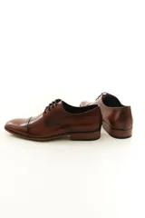 Zapato de vestir acordonado de cuero vacuno marrón, con puntera distinguida y suela con sutil tacón.
