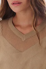 Sweater de tejido de punto calado color lila, con cuello en V y mangas largas.