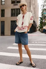 Shorts denim de tiro alto y corte relaxed, confeccionados en tejido vaquero celeste claro. Presentan trabillas en la cintura, diseño de cinco bolsillos, pliegues frontales y cierre con cremallera y botón metálico.