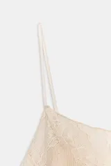 Top de mezcla de viscosa color crema, con escote redondo, tirantes finos y detalle de aplicación de encaje combinado a tono en el busto y en la sección media del torso. El bajo tiene un acabado ondulado.