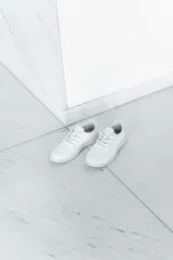 Zapatilla de diseño minimalista confeccionada en lana merino, con suela de EVA y cierre de cordones al tono.