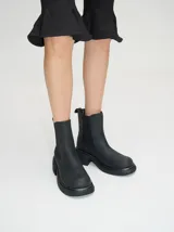 Bota tipo chelsea de cuero vacuno en color rojo con estampado floral grabado en negro. Presenta paneles laterales elásticos, suela de plataforma y taco cuadrado en color negro.