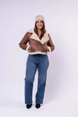 Campera tipo gamulán de cuerina color beige con interior y detalles en corderito blanco. Presenta corte biker, cierre frontal diagonal, bolsillos laterales con cierre y puños con vuelta de corderito.