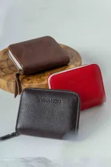 Billetera chica de cuero marrón con cierre de cremallera y logo grabado.