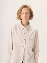 Camisa de manga larga con diseño combinado. Presenta mangas y parte superior delantera y trasera en color negro liso, mientras que el panel central de la espalda destaca por un estampado animal print de leopardo. Cuenta con cuello clásico, cierre frontal de botones y puños abotonados.