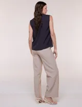 Blusa de gasa sin mangas de calce holgado, marca Sioni. Cuenta con cuello cadete, abertura frontal en V con media cartera de botones, espalda con canesú y pliegue central, y ruedo redondeado.