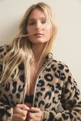 Campera de polar con textura suave y diseño estampado de animal print. Cuenta con cierre frontal completo, cuello alto y bolsillos frontales aplicados.