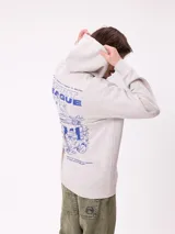 Canguro gris claro con capucha y estampado trasero en azul. El estampado incluye el texto "Spirit League Rusty Team" y una ilustración de una camioneta con animales y tablas de surf.