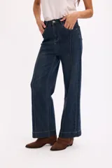 Jean de tiro alto en color azul oscuro, con costuras verticales decorativas en el frente y cierre de botón metálico.