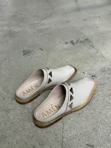 Sueco color beige con apliques metálicos triangulares.