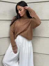 Sweater color marrón de tejido de punto con diseño de ochos y cuello redondo.