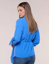 Chaqueta liviana azul de silueta fluida y diseño abierto, con solapa caída, mangas tres cuartos con presilla y argolla metálica, y ruedo irregular.