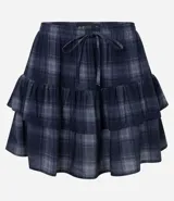 Short pollera de tiro medio con estampado de cuadros escoceses en tonos azul y gris. Presenta diseño de volados sobrepuestos y cintura con lazo ajustable.