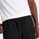 Short deportivo negro de felpa francesa con cintura elástica ajustable con cordón, bolsillos laterales con cierre, bolsillo trasero y logo bordado en la pierna izquierda.