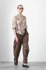 Camisa de manga larga con cuello con volados y botones nacarados. Presenta un estampado romántico de inspiración barroca en tonos azul y beige.